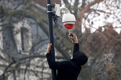 Un manifestante pinta con un spray una cámara de vigilancia en una calle de Nantes, este martes.