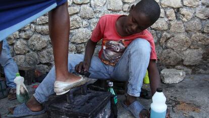 Un ni&ntilde;o saca brillo a los zapatos de una mujer en Puerto Pr&iacute;ncipe, Hait&iacute;. 