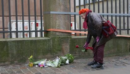 Una dona deixa flors al costat de la sinagoga atacada.