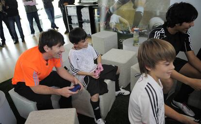 Leo Messi juega a un videojuego con un niño en Barcelona en 2011 con motivo de una promoción de Adidas