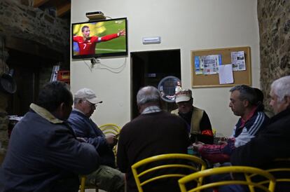 Cristiano Ronaldo celebra uno de sus tres goles en la retransmisión mientras un grupo de hombres juega a las cartas en un bar de Espinhosela, al norte de Portugal.