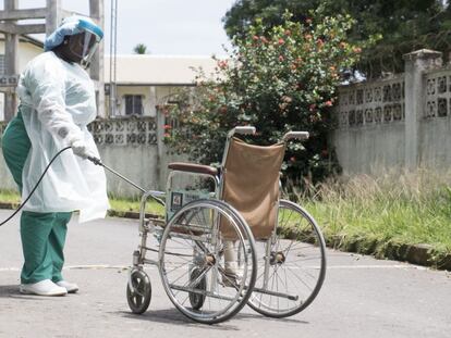 Una enfermera desinfecta una silla de ruedas en Ghana.
