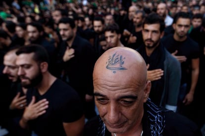 En esta foto, un libanés chiíta partidario de Hezbolá con un tatuaje en la cabeza que dice en árabe, "Oh Ali", se golpea el pecho durante el día sagrado de Ashura, en el sur de Beirut, Líbano.