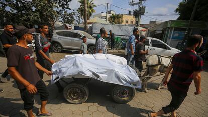 Familiares de las víctimas en los ataques al campamento de Nuseirat (Gaza) trasladan sus cadáveres este jueves en la Franja.