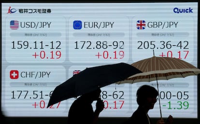 Los ciudadanos pasean junto a una pantalla que muestra la evolución de los tipos de cambio del yen japonés frente al dólar estadounidense, este viernes, en Japón.