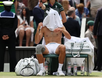 El serbio Novak Djokovic se cambia la camiseta, este domingo durante en Wimbledon.