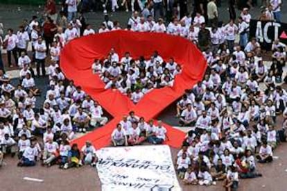 Colectivos de lucha contra el sida despliegan ante la catedral de Barcelona, en mayo de 2000, un tapiz confeccionado en memoria de las víctimas.