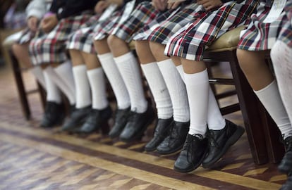 Un grupo de niñas de uniforme con falda. 