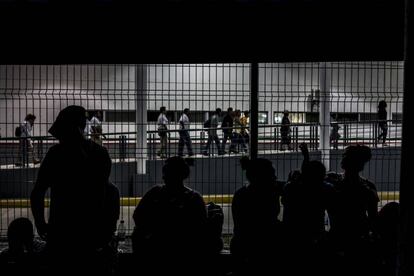 Migrantes centroamericanos esperan en el puente fronterizo la entrega de sus visas humanitarias.
