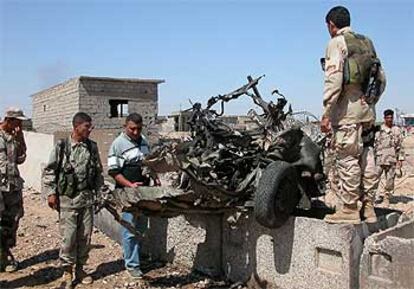 Soldados iraquíes observan los restos del coche bomba en Kirkuk.