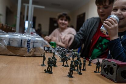 Unos niños juegan con soldados en miniatura en uno de los centros de acogida en Úzhgorod. Dos semanas después del inicio de la guerra, Olha conoció a un niño de Irpin que no era capaz de compartir su experiencia. Tartamudeaba y rompía a llorar cada vez que conversaban. Su madre le contó que un misil les había volado por encima y estallado a pocos metros de casa. Tras varios días de terapia por separado, su madre recuperó poco a poco su entereza, la seguridad en sí misma y la confianza de su hijo. “Al mismo tiempo que su madre mejoraba, el crío me contaba poco a poco lo sucedido y cómo la energía de su madre le había generado un pánico incontrolable al recordar lo sucedido. Llevo años trabajando con niños y es increíble ver como absorben y perciben los sentimientos y emociones de sus padres”, explica.