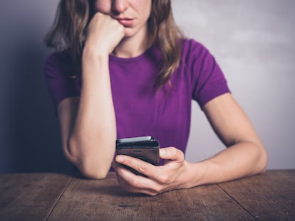 A woman checks her phone.