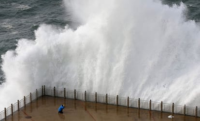 Una gran ola rompe contra el Paseo Nuevo de San Sebastián, donde el temporal ha causado daños y ha obligado a activar la alerta naranja.