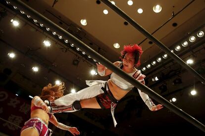 Wrestler Act Yasukawa (R), jumps at Kairi Hojo during their Stardom female professional wrestling show at Korakuen Hall in Tokyo, Japan, December 23, 2015. Professional women's wrestling in Japan means body slams, sweat, and garish costumes. But Japanese rules on hierarchy also come into play, with a culture of deference to veteran fighters. The brutal reality of the ring is masked by a strong fantasy element that feeds its popularity with fans, most of them men. REUTERS/Thomas Peter     SEARCH "WOMEN WRESTLERS" FOR THIS STORY. SEARCH "THE WIDER IMAGE" FOR ALL STORIES