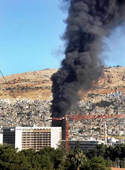 Una columna de humo se eleva sobre el sitio donde ha ocurrido la explosión esta mañana en Damasco.