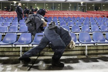 Policiais inspecionam as grades do est&aacute;dio de Hanover.