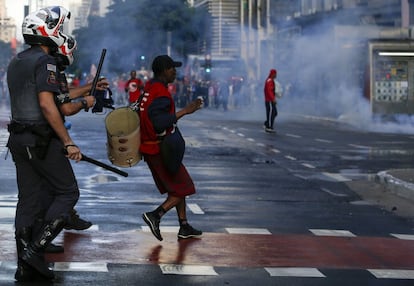 Manifestante do MTST na Paulista é observado por policial.