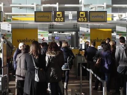 Clientes de Vueling ante los mostradores de facturaci&oacute;n del aeropuerto de Barcelona El Prat.