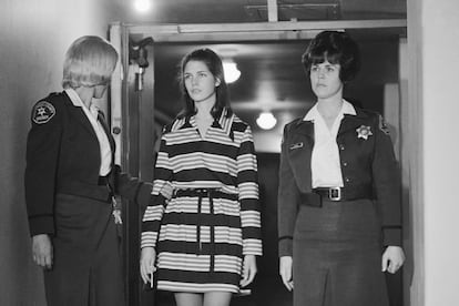 Leslie Van Houten, 19, a member of Charles Manson's "family" who is charged with the murders of Leno and Rosemary LaBianca, is escorted by two deputy sheriffs as she leaves the courtroom in Los Angeles, Dec. 19, 1969, after a brief hearing.