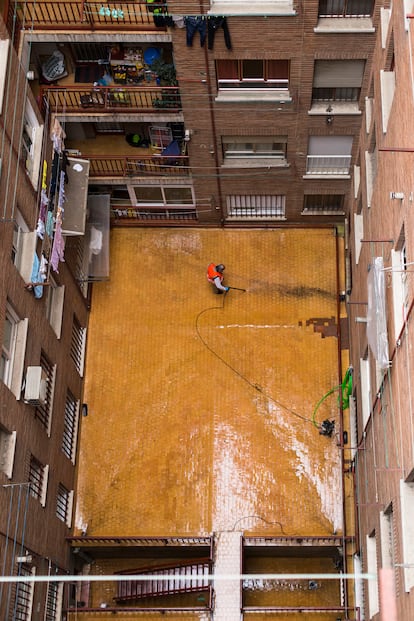 Limpiar el patio con agua a presión es un rito matutino de Héctor Gusta, portero de un edificio de Chamberí