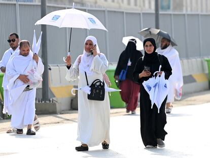 Musulmanes que participan en la peregrinación a la ciudad santa de La Meca, en Arabia Saudí, se protegen del sol con sombrillas, el 14 de junio de 2024.