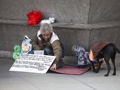 Una persona sin hogar con dos perros, en una calle de Madrid.