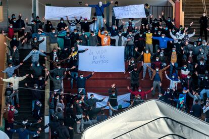 Migrants at a shelter in Gran Canaria holding signs reading: “Death is worse than deportation” and “The life of the dead.”