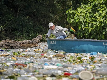 Un pescador saca basura del Lago Suchitlán en Chalatenango (El Salvador), en septiembre de 2022.