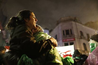 Dos jóvenes favorables al aborto legal se abrazan y lloran bajo la lluvia frente al Congreso argentino,