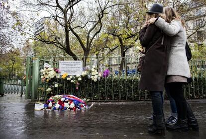 Dos mujeres, delante de la placa conmemorativa de los atentados en los alrededores del bar La Bone Biére, en París.