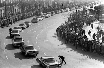 Un operario limpia los excrementos de los caballos al paso de los coches del cortejo en el funeral de Franco.