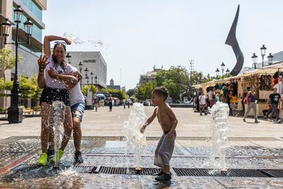 Familias juegan en las fuentes de la Plaza Tapatía en Guadalajara para quitarse el calor.