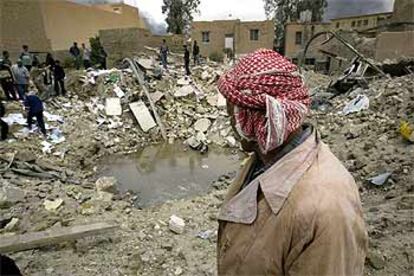 Un iraquí contempla el cráter causado por un misil en Bagdad en la noche del sábado al domingo.