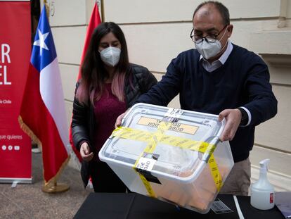 Trabajadores electorales sostienen una caja con votos, el pasado 13 de marzo en Santiago de Chile.