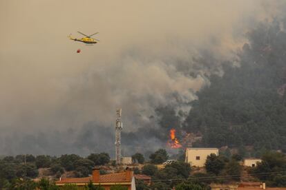 Un helicóptero ayuda en las labores de extinción del fuego, en Navalmoral de la Sierra (Ávila) este lunes. 