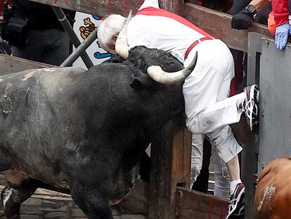 Un mozo es embestido por uno de los toros de la ganadería sevillana de Miura durante el último encierro de los Sanfermines 2024, este domingo, en Pamplona.