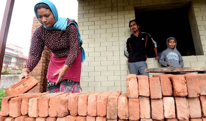 Rabindra (centro) and Anjana Tajale (izquierda) trabajan en la construcción de su nueva vivienda en Bhaktapur, Nepal, el 21 de abril de 2020. El terremoto que asoló el país en abril de 2015 les dejó sin casa y han vivido como desplazados internos hasta ahora.