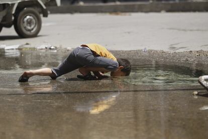 Un niño bebe agua de un agujero creado por un obús en el suelo, que se llenó de agua después de que un ataque con artillería dañara la tubería principal de agua potable del barrio de Karm al-Jabal, en Alepo. Junio de 2013. <br><br> <i> “Cuando publiqué esta foto en 2013 a través de la agencia de noticias Reuters como parte de mi cobertura de la vida en Alepo durante la guerra, algunas personas escribieron comentarios criticando la irrealidad de la imagen. Decían que el fotógrafo debería haberle proporcionado agua limpia al niño en lugar de explotar su imagen. Creo que cualquier cambio de la realidad empieza por ver esa realidad tal y cómo es y no cómo nos gustaría que fuera”. </i> <br>