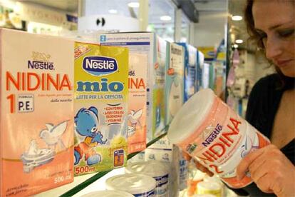 Una cliente de un supermercado de Santander muestra leches infantiles de Nestlé.