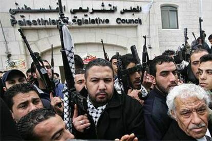 Militantes de Al Fatah se concentran con sus armas en alto frente al Parlamento palestino en Ramala.