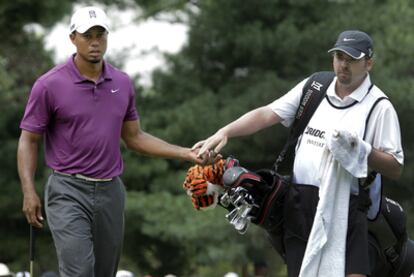 Tiger Woods, ayer, en el Bridgestone Invitational, con Byron Bell cargando su bolsa de palos.