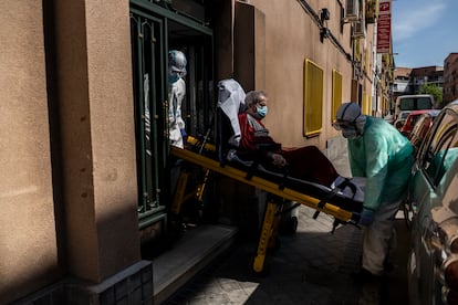 Enrique, de 92 años, con síntomas compatibles con el coronavirus, es trasladado en ambulancia desde su casa, en el madrileño barrio de Vallecas, hasta un hospital. OLMO CALVO