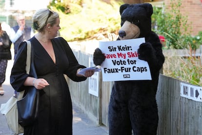 A woman reacts next to a PETA (People for the Ethical Treatment of Animals) activist dressed as a bear outside a polling station in London on Thursday.