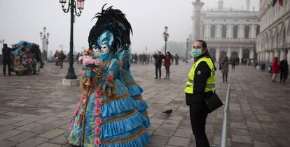 Personas disfrazadas paseando por la plaza de San Marcos en Venecia.