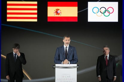 El rei Felip VI, durant el seu discurs, acompanyat per Carles Puigdemont (esquerre) i Thomas Bach (dreta), president del COI.