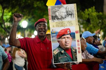 Un partidario del presidente Nicolás Maduro sujeta una imagen de Hugo Chávez tras el cierre de las urnas en Caracas, el domingo.