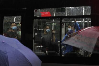 Varios usuarios, con mascarilla para frenar la propagación de la covid, viajan en un autobús bajo la lluvia de Pekín. La Comisión Nacional de Salud de China informó, este miércoles, de 10 nuevos casos de coronavirus detectados el martes, todos ellos procedentes del exterior, con lo que el país asiático acumula ya 38 días sin registrar contactos a nivel local.