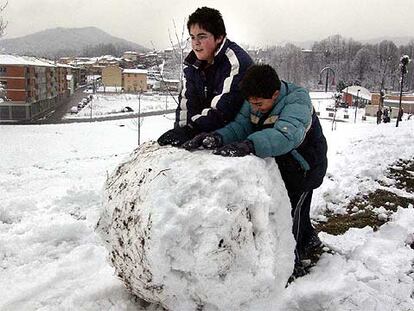 Dos niños jugando con una gran bola de nieve, ayer en Olot (Garrotxa).