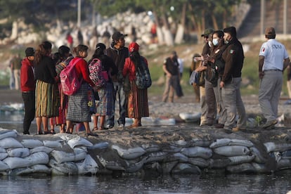 Agentes de inmigración mexicanos detienen a las personas que cruzaron el río Suchiate, la frontera natural entre Guatemala y México, para ver sus documentos de identificación, el día de hoy.