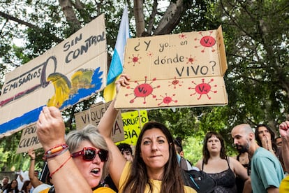 Varias personas sujetan carteles durante la marcha contra el turismo de masas, este sábado en Santa Cruz de Tenerife. 